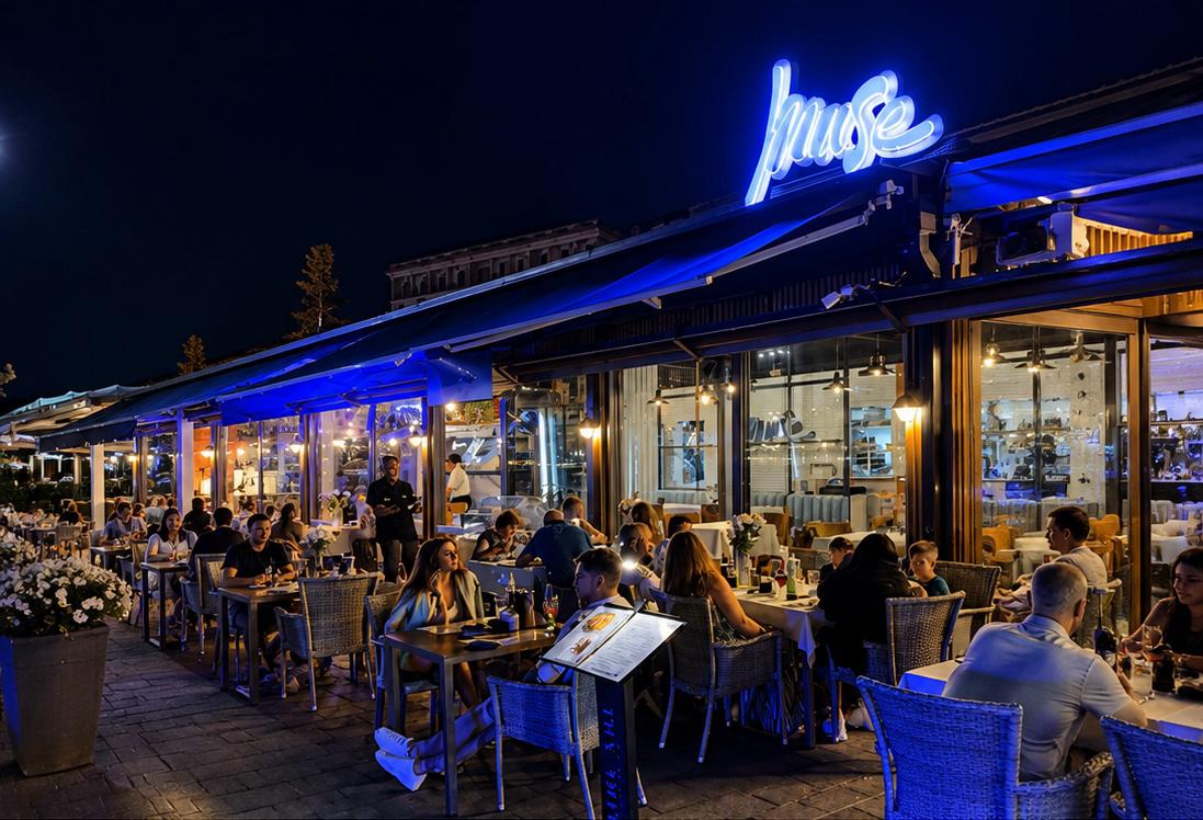 Terasa restaurantului Muse seara, cu lumină albastră și oaspeți la mese
